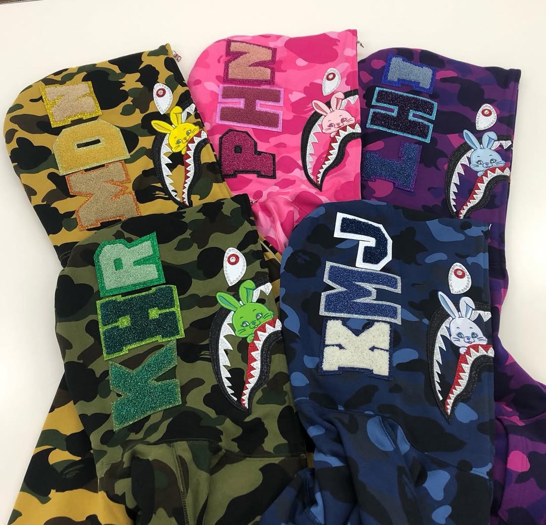 專屬 BAPE 套裝可帥可甜！NewJeans 機場穿搭掀討論，不僅有團員姓名還有這專屬細節！