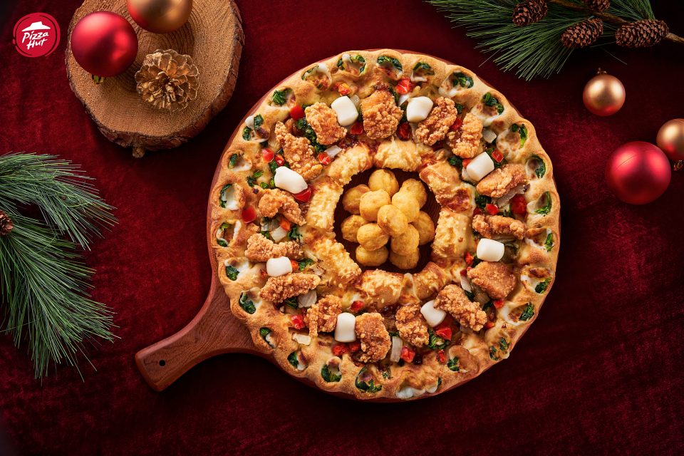 必勝客「聖誕花圈黃金雞比薩」鋪滿先炸後烤的燦金香酥雞與番茄點綴，搭配內外雙圈芝心餅皮並嵌入菠菜，交織出金、紅、綠的聖誕經典色彩