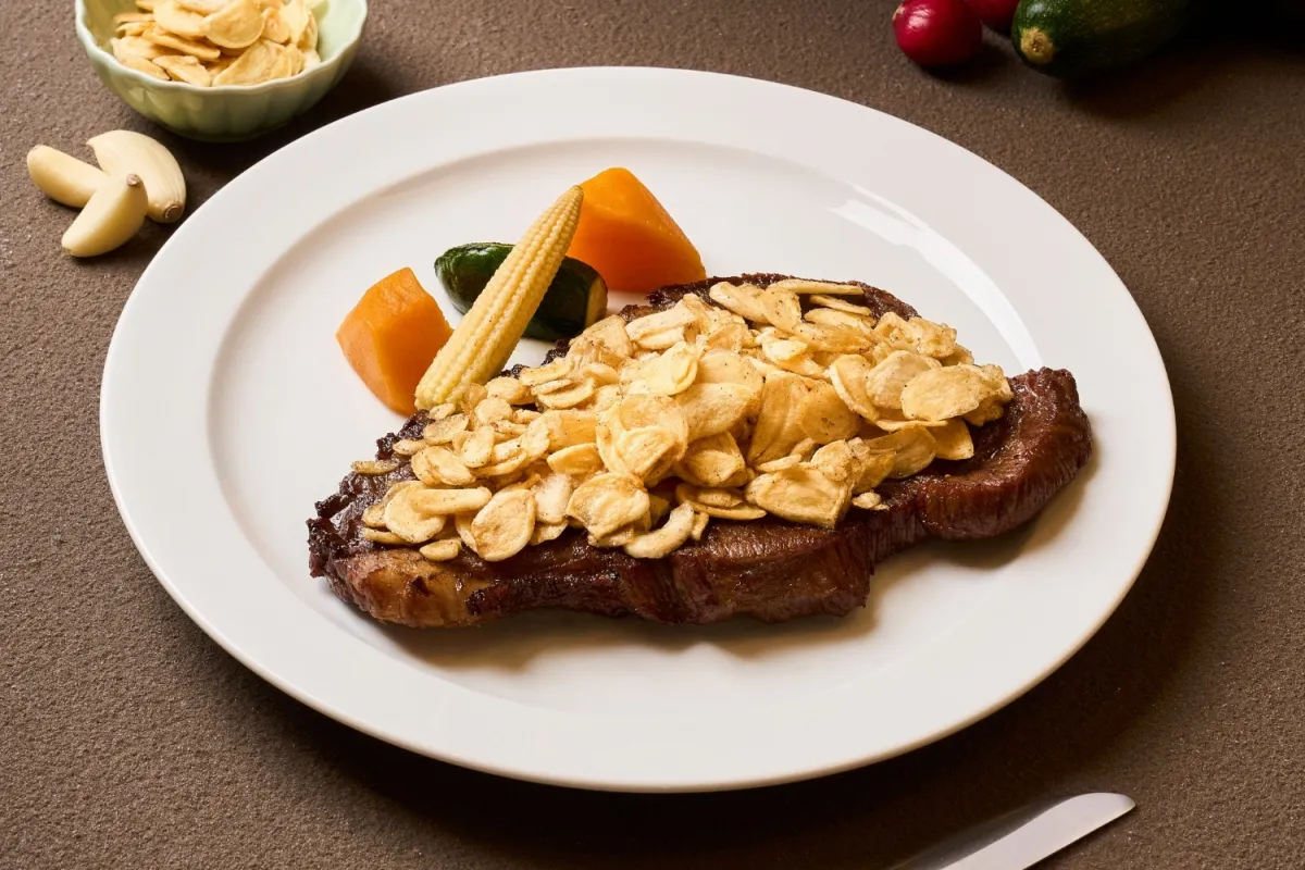 TOK牛排屋主打TOK蒜香重磅牛排，10盎司大份量牛排，撒上香煎蒜片超違規，含自助吧598元