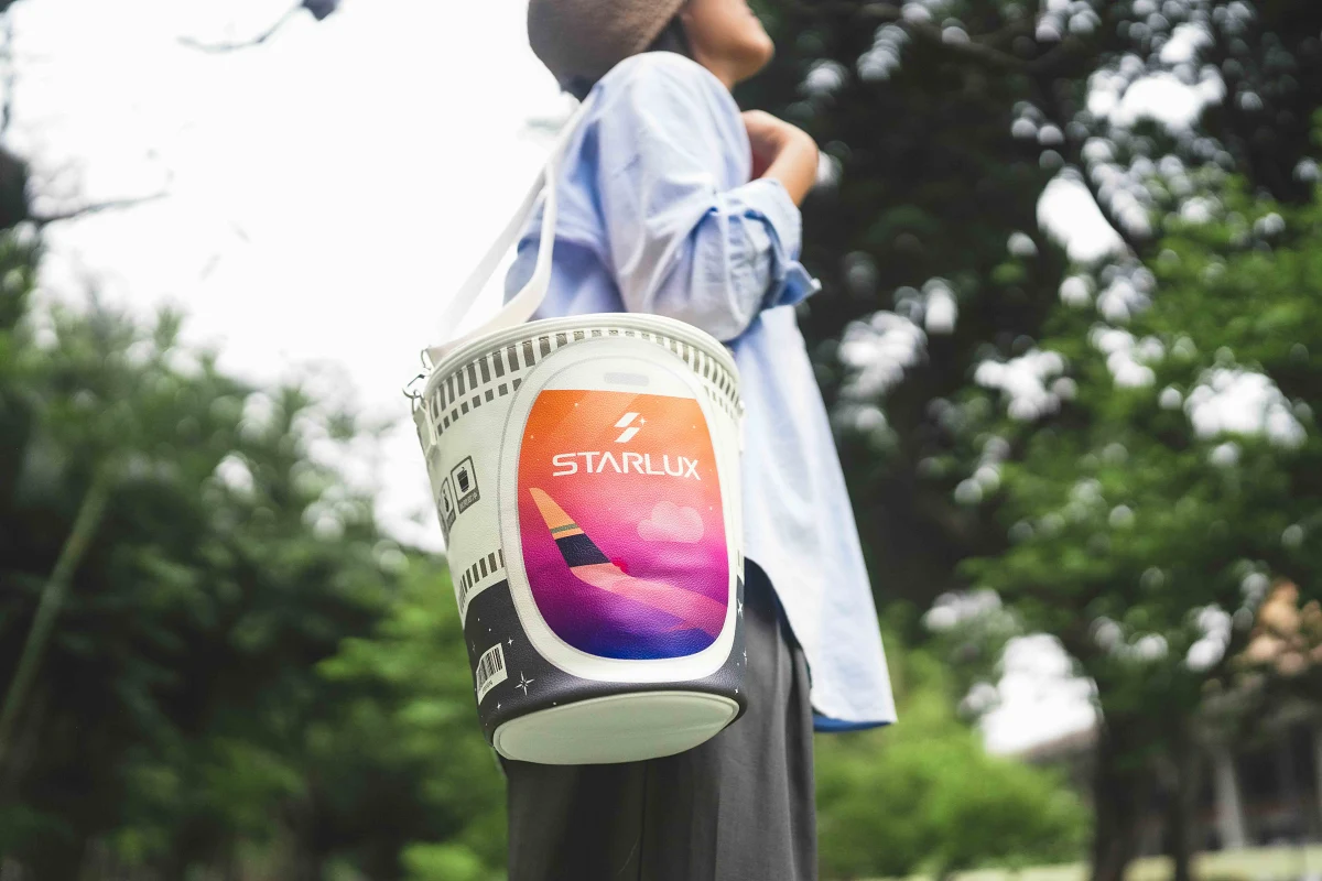 以日清經典杯麵造型為靈感打造,「巨無霸泡麵杯包」是將杯身放大數倍的趣味背包,並在外觀上巧妙融入了飛機魚板、日落機窗與機翼等航空元素